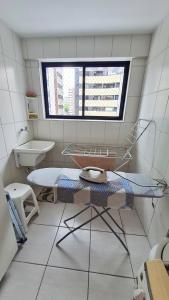 baño con mesa, lavabo y ventana en Apartamento Monte Paradiso, en Maceió