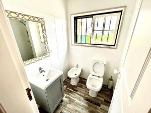 a bathroom with a sink and a toilet and a mirror at Carcavelos Summer Beach in Carcavelos