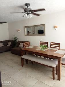 een woonkamer met een houten tafel en een plafondventilator bij Departamento en puente del mar in Acapulco