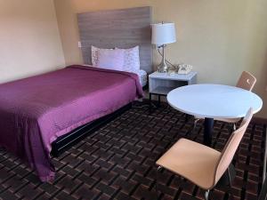 ミルフォードにあるFairBridge Inn Expressのベッド、テーブル、椅子が備わるホテルルームです。
