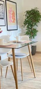 une table en verre avec des chaises blanches et une plante en pot dans l'établissement ST-Apartment Charming 1 mit Terrasse und Garten, 3 Zimmer in Geislingen, à Geislingen an der Steige