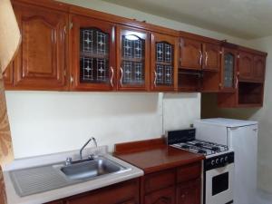 a kitchen with wooden cabinets and a sink and a stove at Cabañas del Coronel in Zacatlán