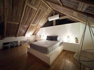 波波尤的住宿－Jungle Shacks : Hoku Casita，一间带一张床的卧室,位于带木制天花板的房间内