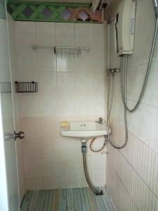 La salle de bains est pourvue d'un lavabo et d'une douche. dans l'établissement Smile Capsule Hostel, à Chiang Mai