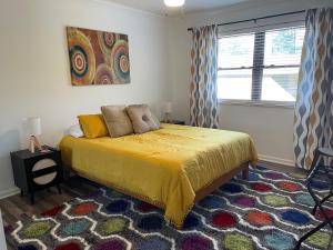 a bedroom with a bed with a yellow bedspread and a window at Lucky #9 Hot Springs in Hot Springs