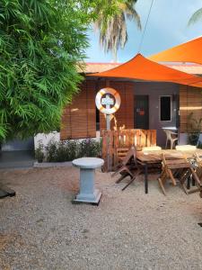 a patio with a table and chairs and an umbrella at Langkawi Village Budget Rooms in Pantai Cenang