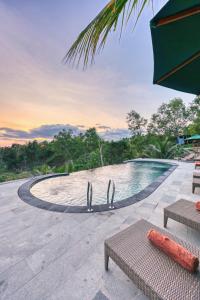 a swimming pool at a resort with a sunset at Beten Juwet in Nusa Penida