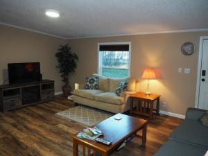 a living room with a couch and a table at The Green Lake Getaway - Shared Lake Access! in Interlochen