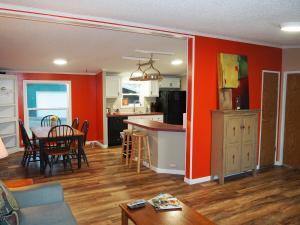 a kitchen and living room with red walls at The Green Lake Getaway - Shared Lake Access! in Interlochen