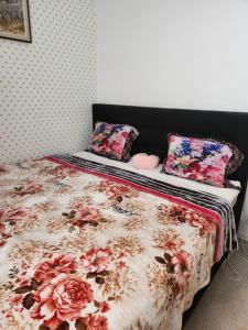 a bed with a floral comforter and pillows on it at Stockholm Guest apartment 