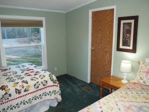 a bedroom with a bed and a window and a table at The Green Lake Getaway - Shared Lake Access! in Interlochen