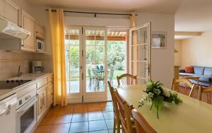 a kitchen and dining room with a table and chairs at Lagrange Vacances Domaine de Fayence in Fayence