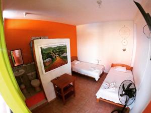 Habitación pequeña con 2 camas y espejo. en Shoffi's House Backpackers, en Tarapoto