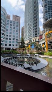 a clock in the middle of a city with tall buildings at One Bedroom Condo with fast wifi at Eastwood Lafayette tower Quezon city in Manila