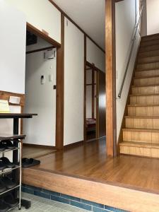 ein Büro mit einer Treppe und Holzböden in der Unterkunft りんくう館笠松 関西空港 in Sano