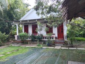 een huis met een rode deur en een tuin bij Quoc Phuong Riverside Homestay in Ben Tre