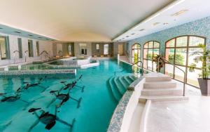 an indoor swimming pool with blue water in a building at Lagrange Vacances Domaine de Fayence in Fayence