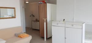 a white room with a bed and a cabinet at Apartmaji Koper - MARINA STYLE in Koper