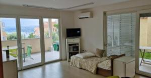 uma sala de estar com uma cama e portas de vidro deslizantes em Apartmaji Koper - MARINA STYLE em Koper