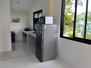 a kitchen with a refrigerator with a microwave on top of it at Dream seaview bungalows in Haad Pleayleam