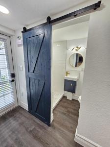 a large wooden door in a bathroom with a sink at The Hideaway DT Orlando Tiny Home w Free Parking in Orlando