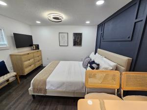 een slaapkamer met een bed, een dressoir en een tv bij The Hideaway DT Orlando Tiny Home w Free Parking in Orlando