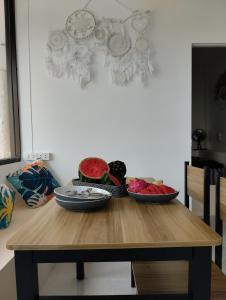 a wooden table with two bowls of fruit on it at Dream seaview bungalows in Haad Pleayleam