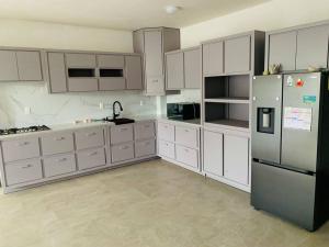 a kitchen with white cabinets and a refrigerator at Casa con alberca. in Tamazunchale