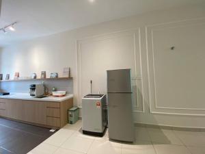 a kitchen with a refrigerator in the middle of a room at Puchong New Private Pool & Jacuzzi up to 30 Pax in Puchong