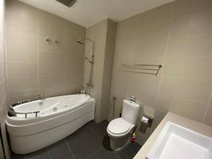 a bathroom with a tub and a toilet and a sink at Puchong New Private Pool & Jacuzzi up to 30 Pax in Puchong