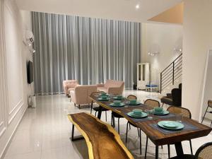 Puchong New Private Pool & Jacuzzi up to 30 Pax في بوتشونغ: غرفة معيشة مع طاولة وكراسي خشبية