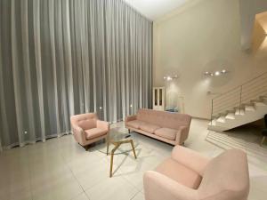 a living room with two pink chairs and a couch at Puchong New Private Pool & Jacuzzi up to 30 Pax in Puchong