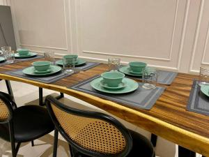 a wooden table with green bowls and plates on it at Puchong New Private Pool & Jacuzzi up to 30 Pax in Puchong