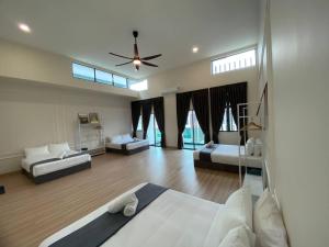 a large room with two beds and a ceiling fan at Puchong New Private Pool & Jacuzzi up to 30 Pax in Puchong +34 photos