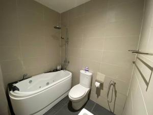 a bathroom with a tub and a toilet and a sink at Puchong New Private Pool & Jacuzzi up to 30 Pax in Puchong