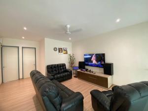 a living room with black leather furniture and a flat screen tv at Puchong New Private Pool & Jacuzzi up to 30 Pax in Puchong