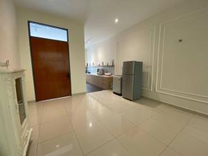 a large kitchen with a refrigerator and a door at Puchong New Private Pool & Jacuzzi up to 30 Pax in Puchong
