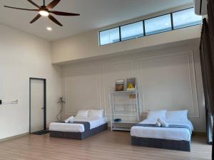 a bedroom with two beds and a ceiling fan at Puchong New Private Pool & Jacuzzi up to 30 Pax in Puchong