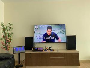 a flat screen tv sitting on top of a wooden entertainment center at Puchong New Private Pool & Jacuzzi up to 30 Pax in Puchong