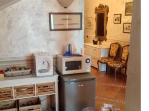 uma cozinha com um micro-ondas em cima de um frigorífico em B&B Torre in Langa em Carrù