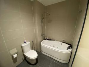 a bathroom with a toilet and a bath tub at Puchong New Private Pool & Jacuzzi up to 30 Pax in Puchong