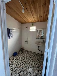 La salle de bains est pourvue d'une douche et d'un lavabo. dans l'établissement Chú Ba Farmstay - cách Đà Lạt 40km, 