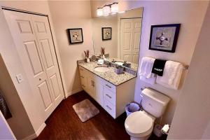 La salle de bains est pourvue de toilettes, d'un lavabo et d'un miroir. dans l'établissement ABC Vacation Homes, à Kissimmee