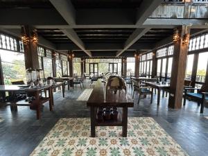 Amigo Pu Luong في Làng Bang: غرفة طعام مع طاولات وكراسي ونوافذ