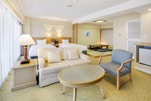 Habitación de hotel con cama, sofá y TV en Hotel Resorpia Atami, en Atami