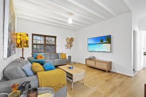 ein Wohnzimmer mit einem Sofa und einem Tisch in der Unterkunft Golden Sands in Henley Beach South