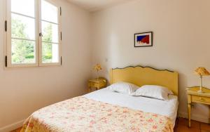 a bedroom with a bed and two windows at Lagrange Vacances Domaine de Fayence in Fayence
