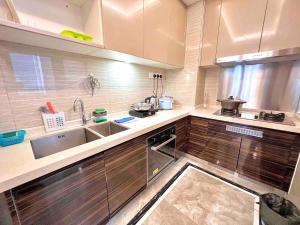 una cocina con armarios de madera y fregadero en RnF Princess Cove romantic unit by CK Group, en Johor Bahru
