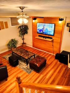 a living room with a flat screen tv on the wall at Luxury Basement Apartment LA CASA in Winchester
