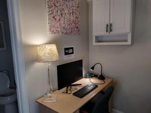 een bureau met een computer en een lamp erop bij Luxury Basement Apartment LA CASA in Winchester